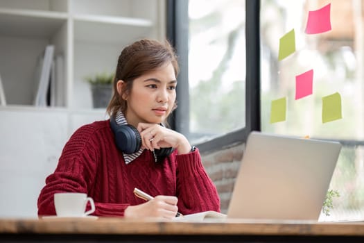 Asian female student study online in class, study online, wearing headphones, watching video call, zooming, happy asian female learning language online with computer laptop