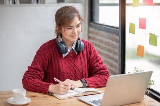 Asian female student study online in class, study online, wearing headphones, watching video call, zooming, happy asian female learning language online with computer laptop