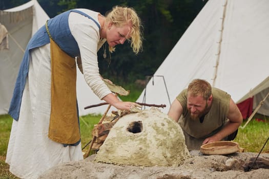 Hojbjerg, Denmark, July 29, 2023: A married couple makes a clay oven at the Viking festival