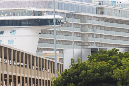 A huge tourist cruise ship moored in the port of a small European town. Mid shot