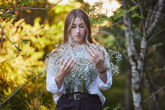 Ornhoj, Denmark, July 4, 2023: Cute girl with flowers at sunset.