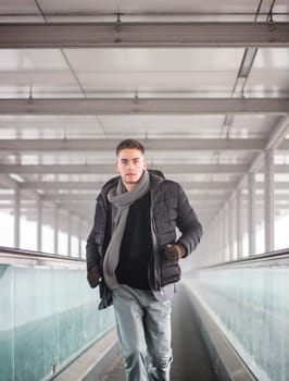 A man walking down a walkway in a building