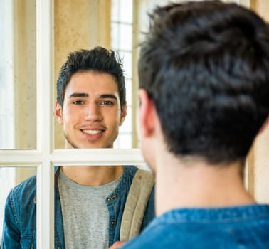 A man looking at himself in the mirror