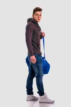 A man holding a blue bag while standing on a white background