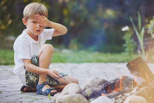 Ornhoj, Denmark, July 4, 2023: boy playing by the bonfire.