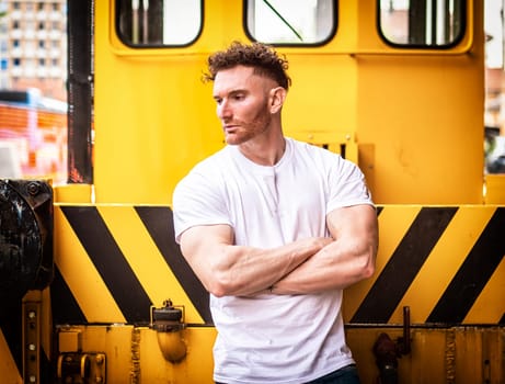 A man standing in front of a yellow train