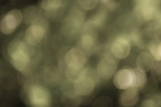 Gray-yellow bokeh on a dark background. Abstract background. Backdrop