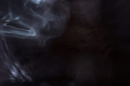 Abstract white swirling smoke on a dark background. Backdrop