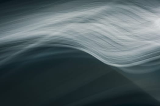 Abstract waves in the cold ocean. Dark background with enlightenment. Backdrop