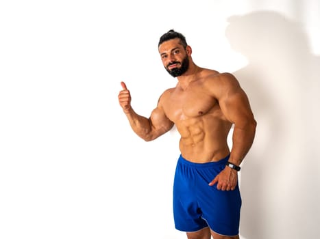 A shirtless man with a goatee giving a thumbs up. Photo of a confident man with a thumbs up gesture