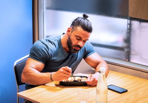 A man sitting at a table with a plate of food. Photo of a man enjoying a delicious meal at a table