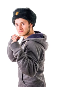 A man in a russian hat is posing with his fist raised, ready for a fight with a menacing look in his blue eyes