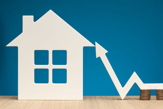 Rising rental prices. Increasing the cost of rental housing. The white arrow on the graph points up next to the model of the house, as a symbol of an increase in value,. High quality photo