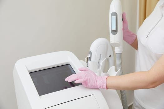 Before a skincare session, a professional cosmetologist ensures the laser equipment is perfectly set up
