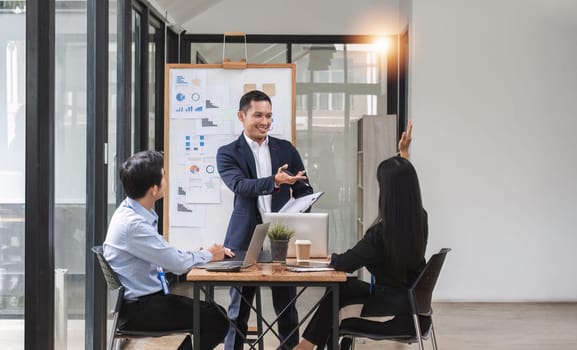 Professional businessman presenting to colleagues in conference room explaining growth chart.