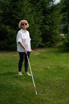 Elderly blind woman walking in the park