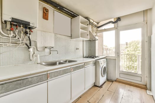 a kitchen area with white cabinets and an open door leading to the outside patio, which has been used for several years