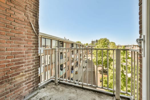 an outside area with a brick wall and metal railing on the side of a building that is being used for apartments