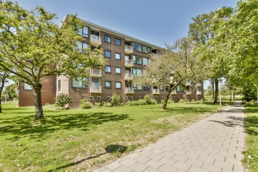 an apartment building with trees in the front and walkway leading up to it on a sunny day, taken from above