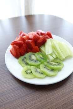 Ripe half kiwi fruit on a plate .