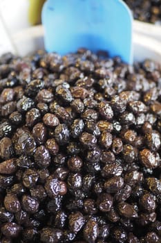 slices black olives with spoon in a bowl