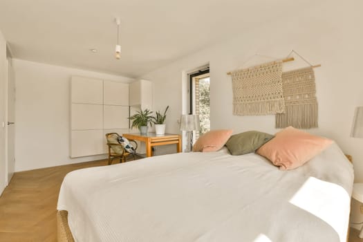 a bedroom with a bed, desk and window in the room that looks out onto the garden view from outside