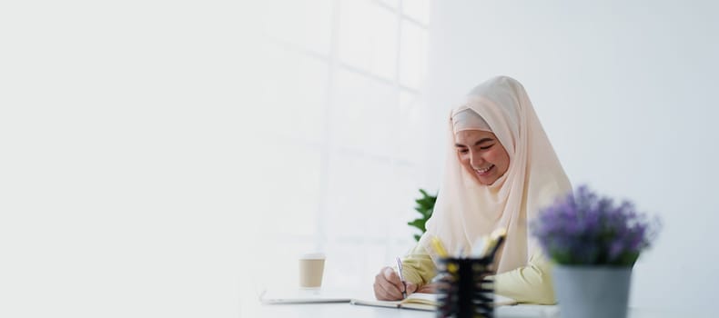 Muslim women use calculators, computers, and laptops to check their accounts at work