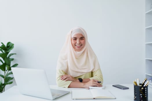 Muslim women use calculators, computers, and laptops to check their accounts at work