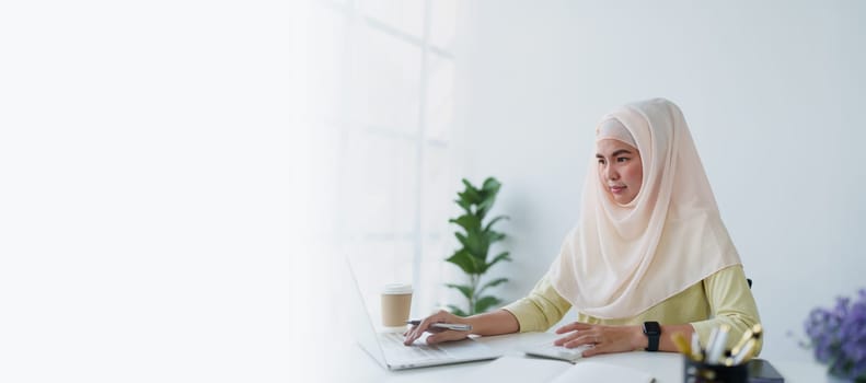 Muslim women use calculators, computers, and laptops to check their accounts at work