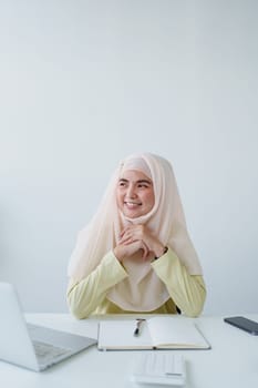 Muslim women use calculators, computers, and laptops to check their accounts at work