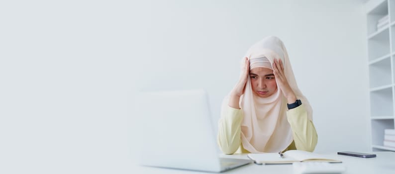 Muslim female employee working in office burnout