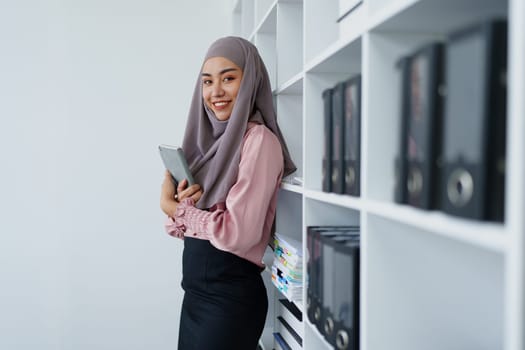 Muslim female employee Searching for documents in the office