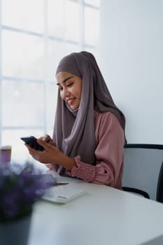 Muslim female employee Using the phone to talk to customers in the office