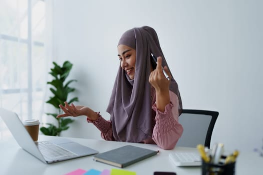 Muslim female employee Conferencing via computer during work