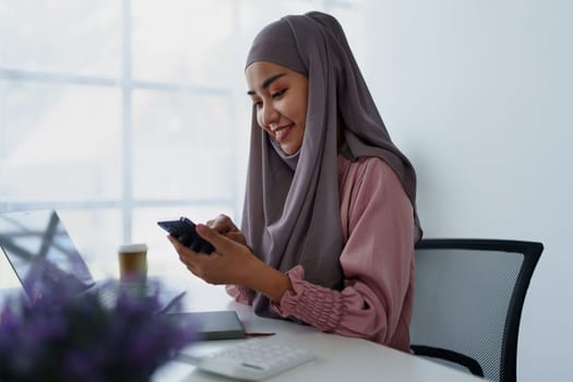 Muslim female employee Using the phone to talk to customers in the office