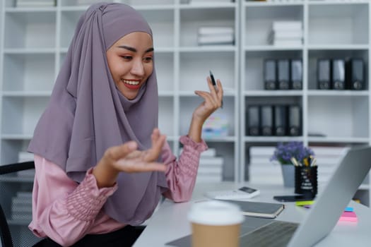 Muslim female employee Conferencing via computer during work