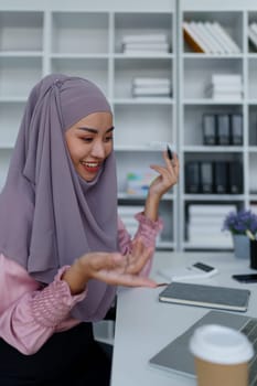 Muslim female employee Conferencing via computer during work