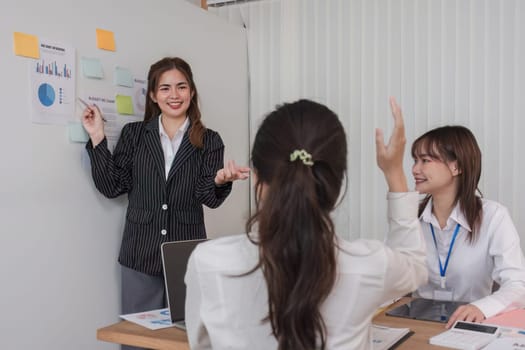 Female Operations Manager Holds Meeting Presentation for a Team of Economists. Asian Woman Uses Digital Whiteboard with Growth Analysis, Charts, Statistics and Data. People Work in Business Office..