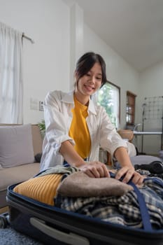 Portrait of beauty asian traveler woman pack prepare stuff and outfit clothes in suitcase travel bag luggage for summer, holiday, weekend, tour, journey, vacation trip at home.