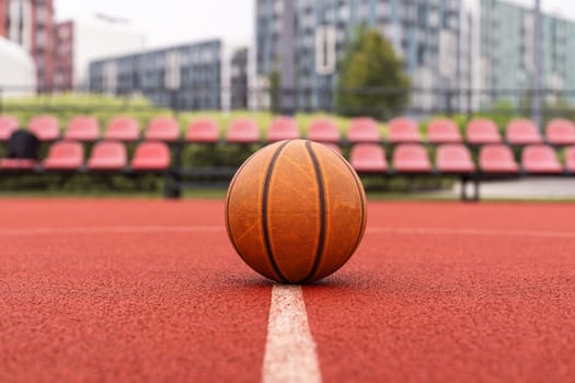 Orange basketball on brown court of gymnasium sport floor. Street basketball concept. High quality photo