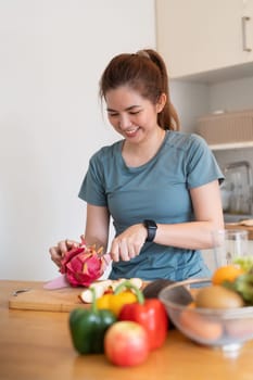 Woman asian cutting fruits and vegetable to prepare a smoothie in the kitchen at home.
