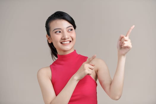 Young beautiful woman smiling and pointing with two hands and fingers to the side.