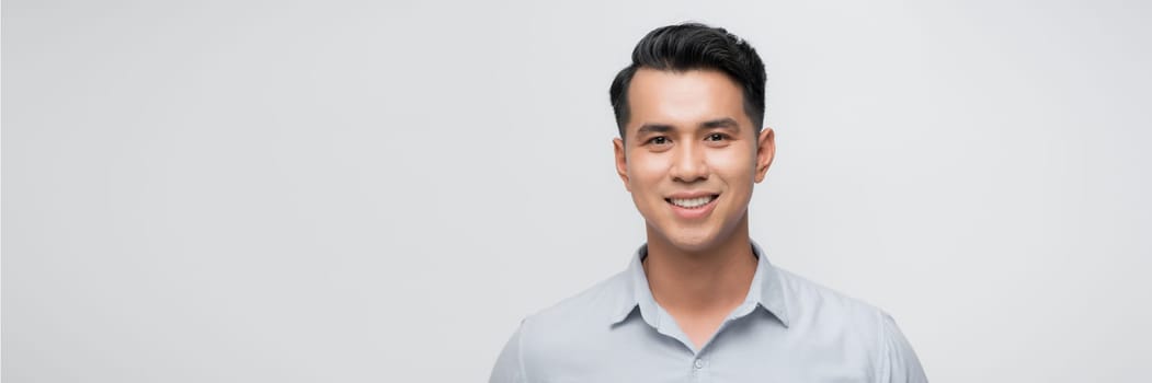 Close up portrait of smiling handsome guy in gray t-shirt isolated on white background