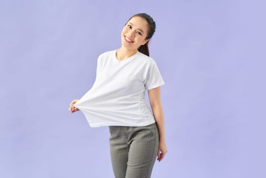 Slender woman wearing big t shirt, isolated on violet