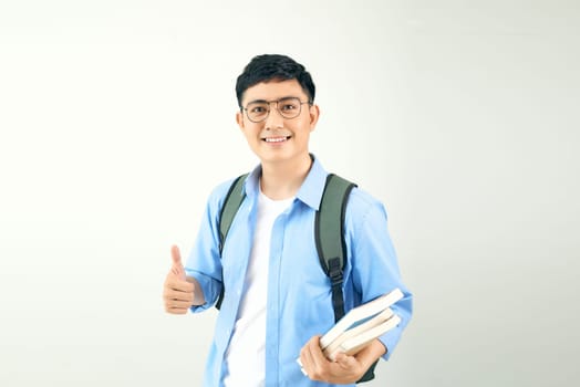 Young smiley student holding books carrying backpack, isolated on a white background.