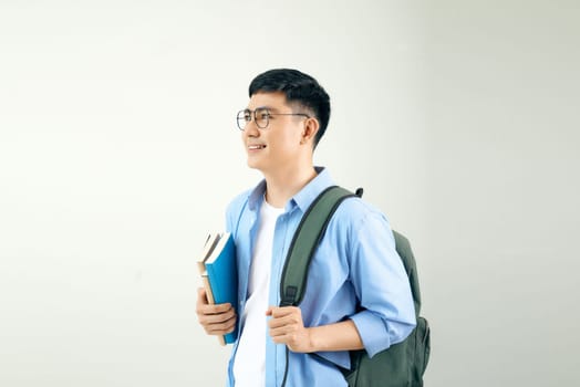 Smiling young man student with backpack hold books isolated on white background.