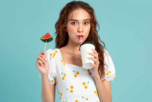 Beautiful young woman with slice of fresh watermelon and juice on blue background