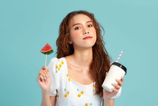 pretty woman drinks a fruit juice from cup holds slice of watermelon ice cream