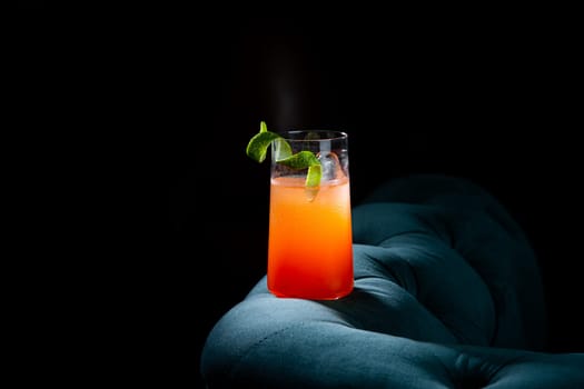 bright tropical cocktail with lime peel and gradient color in a transparent glass