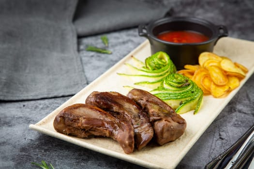 meat ribs with avocado, chips and ketchup on a white plate